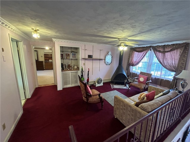 carpeted living room with ceiling fan, a textured ceiling, crown molding, and a wood stove