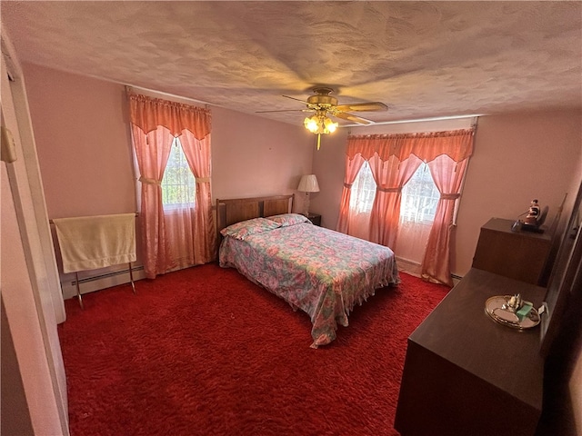 carpeted bedroom featuring a textured ceiling, baseboard heating, and ceiling fan