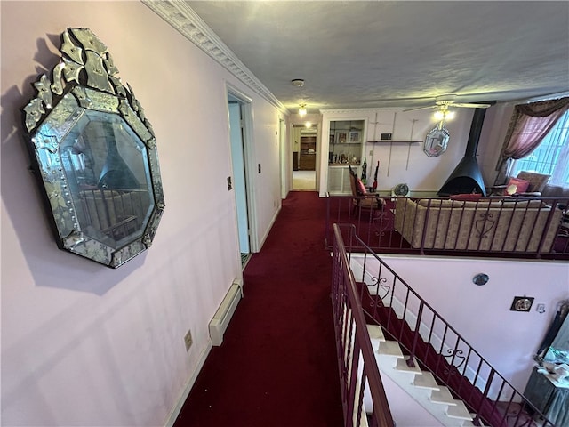 interior space featuring ornamental molding, dark carpet, and baseboard heating