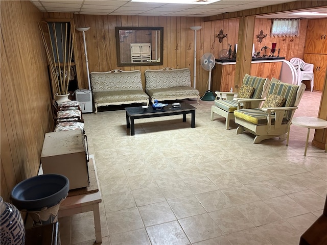 tiled living room featuring a paneled ceiling and wooden walls