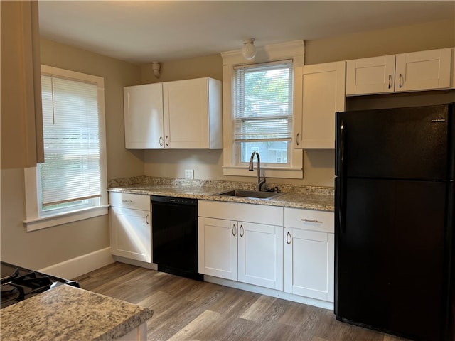 kitchen with black appliances, white cabinetry, and sink