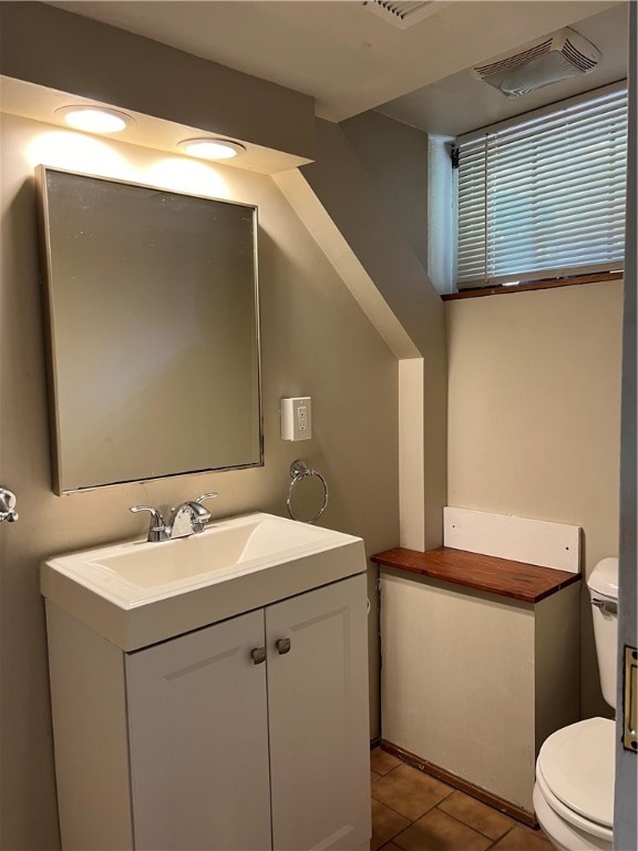 bathroom featuring tile patterned flooring, vanity, and toilet