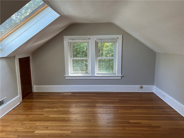 additional living space with wood-type flooring, lofted ceiling, and a textured ceiling