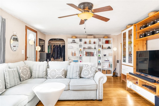 living room featuring light hardwood / wood-style flooring and ceiling fan