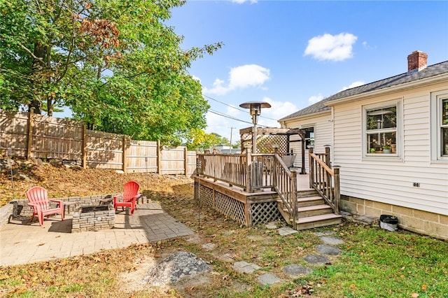 view of yard featuring a fire pit, a deck, and a patio area