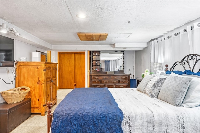 bedroom with a textured ceiling and light colored carpet