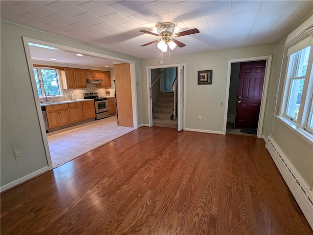 unfurnished living room with ceiling fan, light hardwood / wood-style flooring, and a baseboard radiator