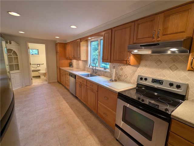 kitchen featuring decorative backsplash, appliances with stainless steel finishes, light tile patterned floors, and sink