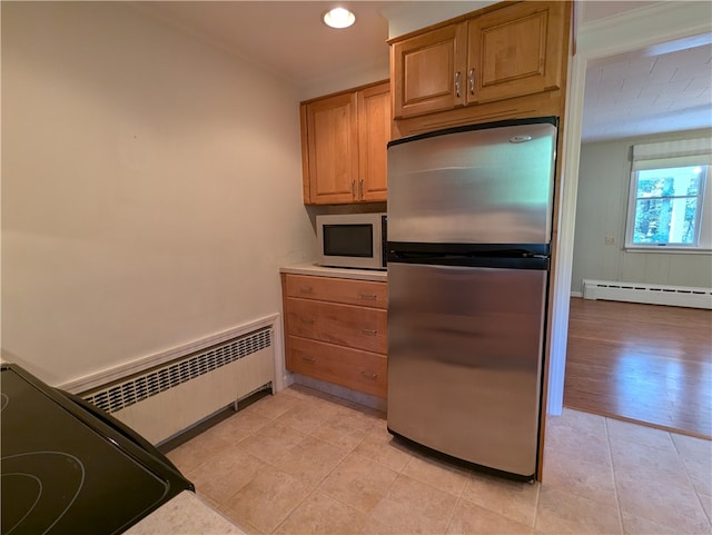 kitchen with stainless steel fridge, stove, light hardwood / wood-style flooring, and a baseboard radiator