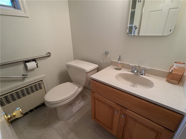 bathroom with vanity, toilet, radiator heating unit, and tile patterned floors