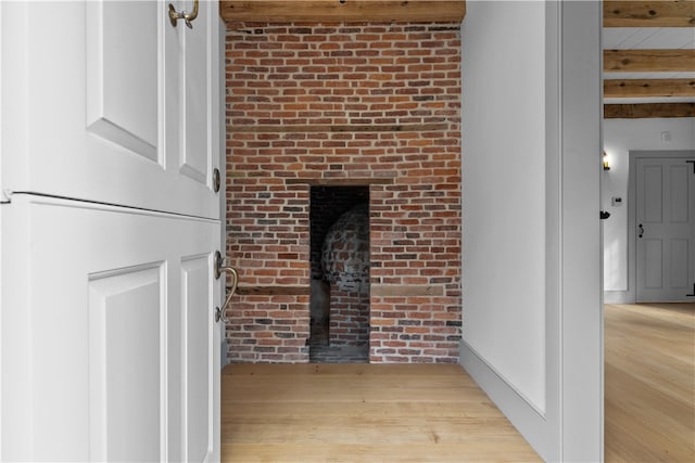 interior space with wood-type flooring, a fireplace, and beam ceiling