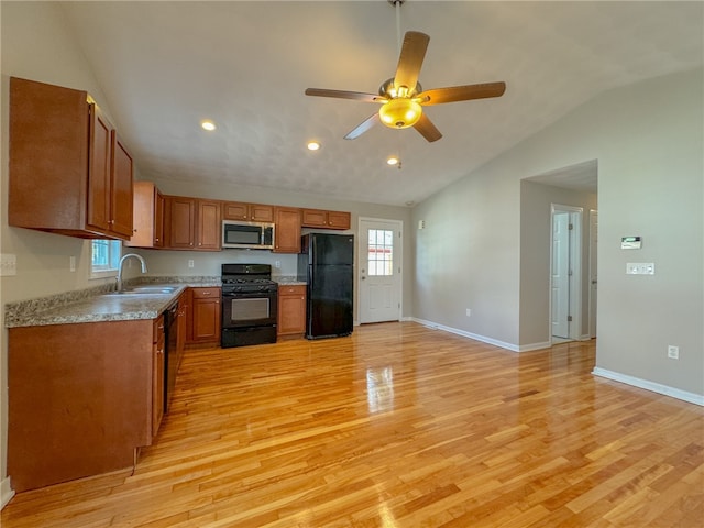 kitchen featuring sink, lofted ceiling, light hardwood / wood-style floors, and black appliances