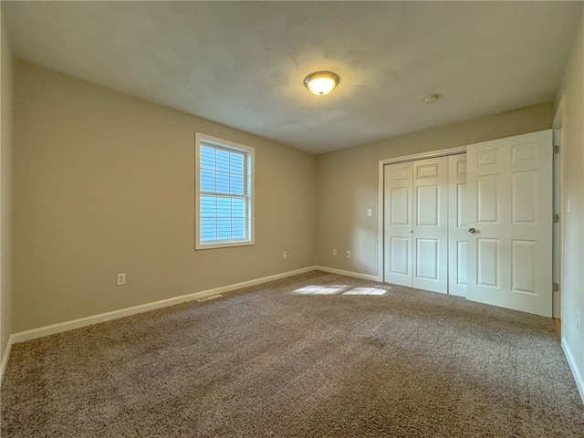 unfurnished bedroom featuring carpet floors and a closet