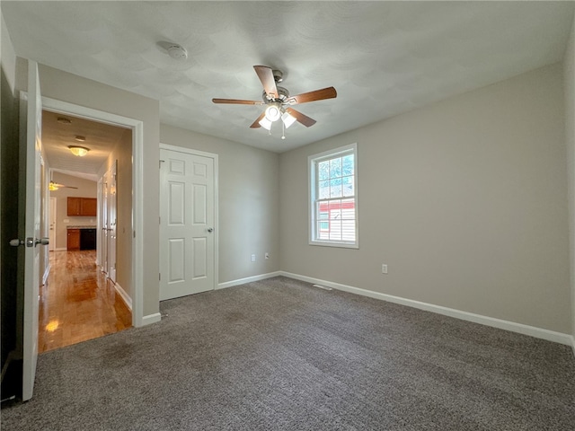 carpeted spare room featuring ceiling fan