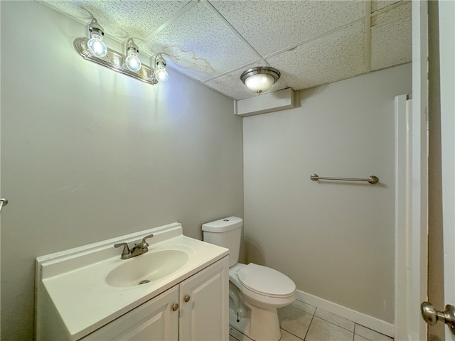 bathroom featuring a drop ceiling, vanity, toilet, and tile patterned floors