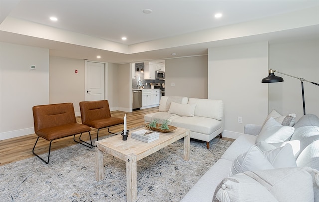 living room with light hardwood / wood-style floors and sink