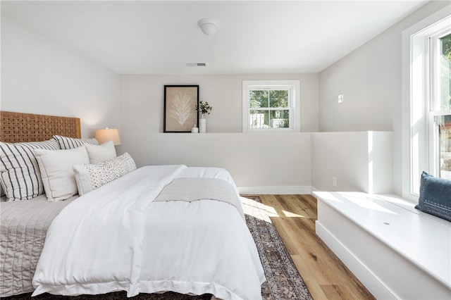 bedroom with light hardwood / wood-style flooring and multiple windows