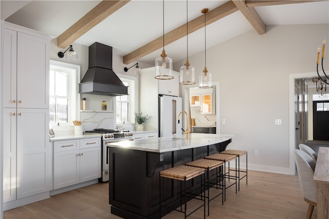 kitchen with white cabinets, gas stove, plenty of natural light, and custom range hood