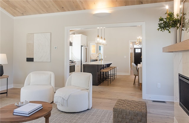 living room featuring wooden ceiling, sink, light hardwood / wood-style flooring, and a premium fireplace