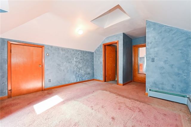 additional living space featuring carpet flooring, vaulted ceiling with skylight, and baseboard heating