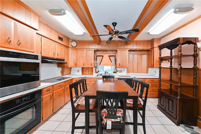 kitchen featuring ceiling fan, light tile patterned flooring, beamed ceiling, black appliances, and sink