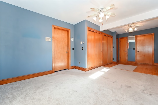 carpeted spare room with beam ceiling and ceiling fan