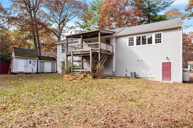 back of property featuring a yard, a storage shed, and a deck