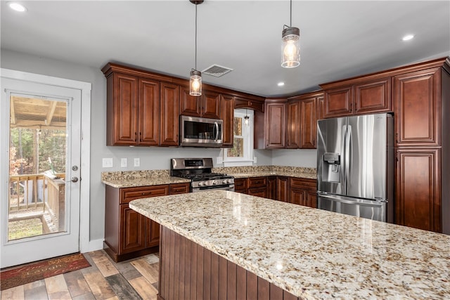 kitchen with light stone counters, stainless steel appliances, light wood-type flooring, and hanging light fixtures