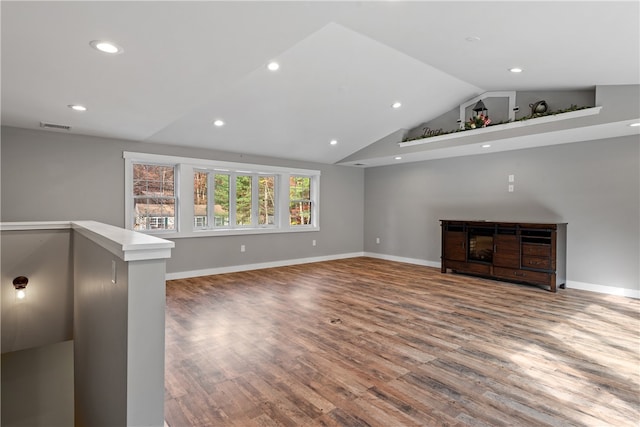 unfurnished living room with hardwood / wood-style floors and vaulted ceiling