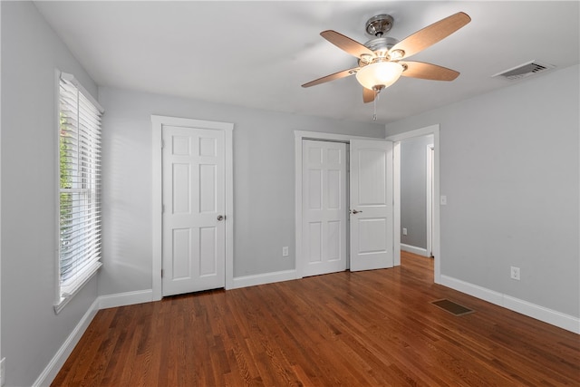 unfurnished bedroom featuring dark wood-type flooring and ceiling fan