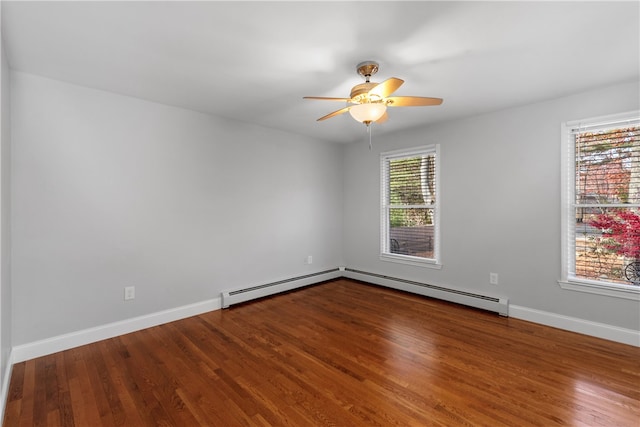 spare room featuring a baseboard heating unit, hardwood / wood-style flooring, and ceiling fan