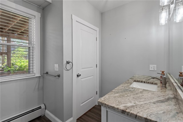 bathroom with vanity, baseboard heating, and wood-type flooring