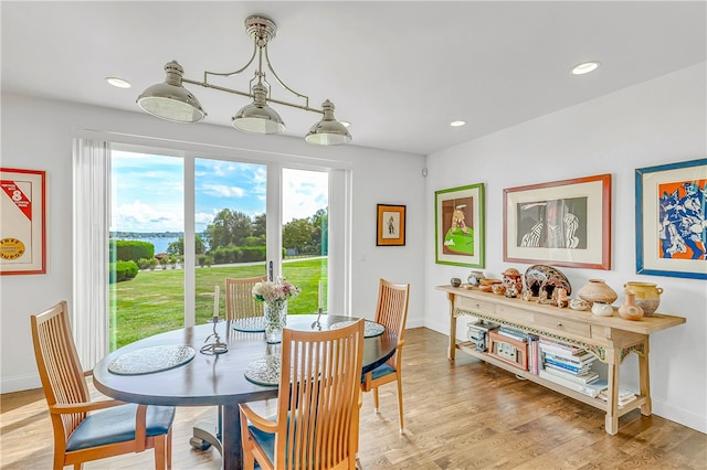 dining space featuring an inviting chandelier and light hardwood / wood-style floors