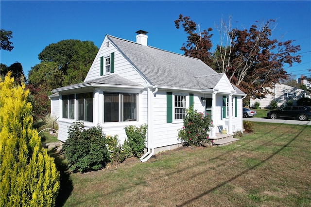 view of front facade featuring a front lawn and a sunroom