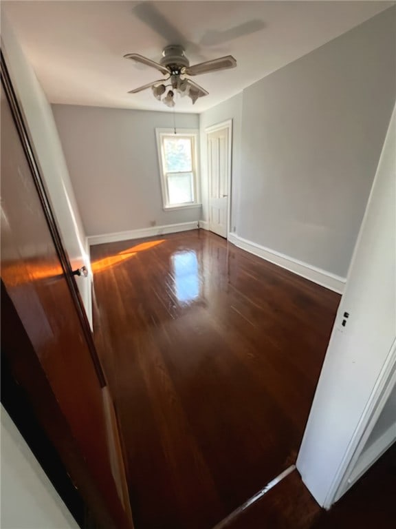 unfurnished room featuring ceiling fan and dark hardwood / wood-style flooring