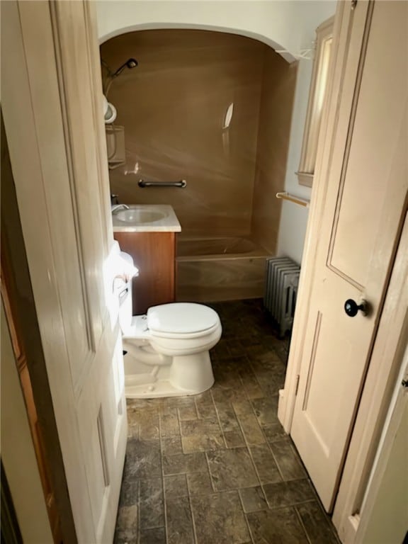 full bathroom featuring bathtub / shower combination, radiator heating unit, vanity, and toilet