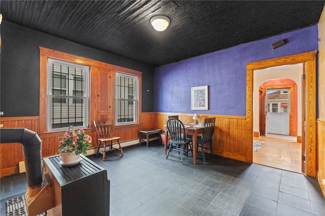 interior space featuring a baseboard radiator, wooden walls, and tile patterned floors