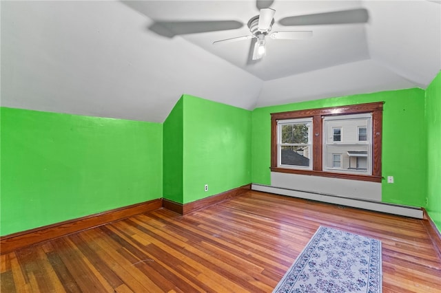 interior space with ceiling fan, baseboard heating, vaulted ceiling, and light hardwood / wood-style flooring