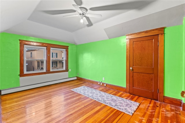 unfurnished room with ceiling fan, baseboard heating, light wood-type flooring, and lofted ceiling