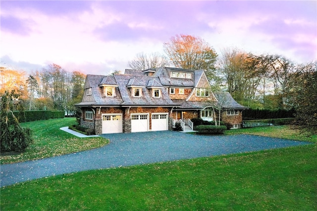 view of front of house with a garage, a yard, and covered porch