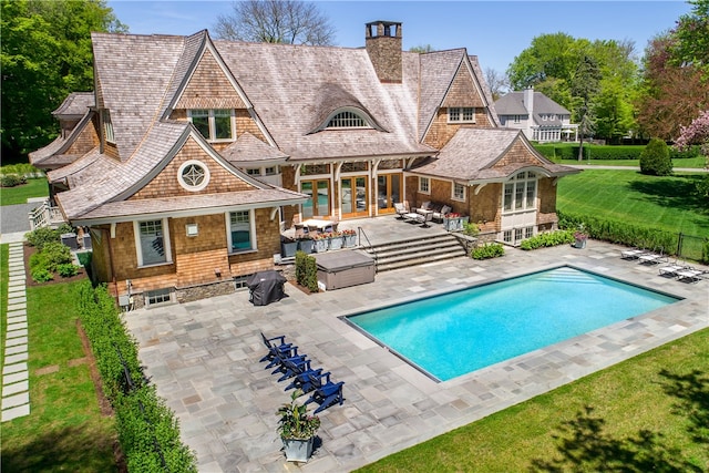 rear view of house featuring an outdoor living space, a patio, and a lawn