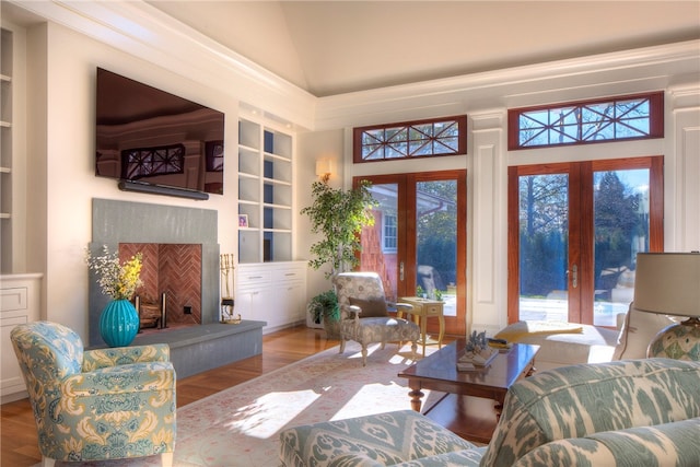 living room with vaulted ceiling, a wealth of natural light, hardwood / wood-style floors, and french doors