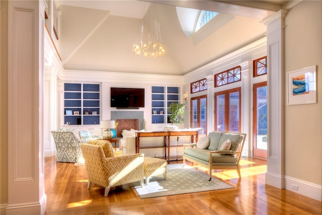 living area featuring ornate columns, high vaulted ceiling, an inviting chandelier, and light wood-type flooring