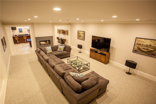 living room with vaulted ceiling, a tile fireplace, and light colored carpet