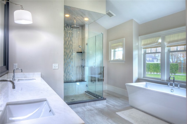 bathroom featuring vanity, shower with separate bathtub, lofted ceiling, and hardwood / wood-style floors