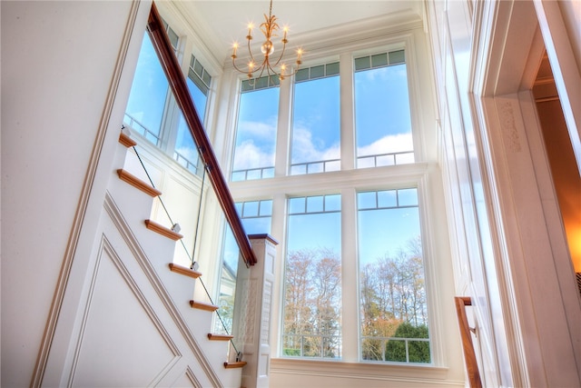 interior details with ornamental molding and a notable chandelier