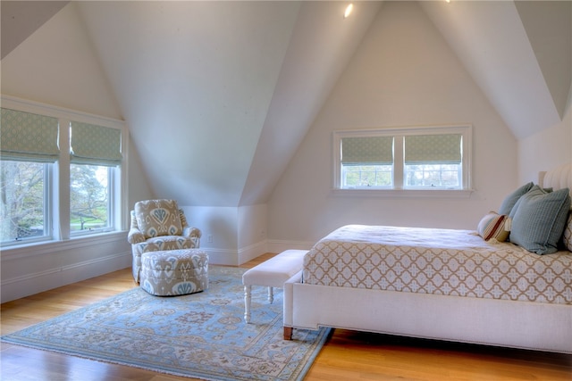 bedroom with lofted ceiling, hardwood / wood-style floors, and multiple windows