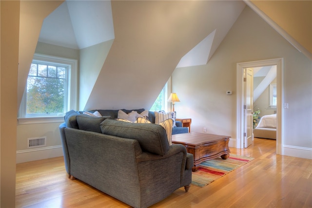 living room with light hardwood / wood-style flooring and vaulted ceiling