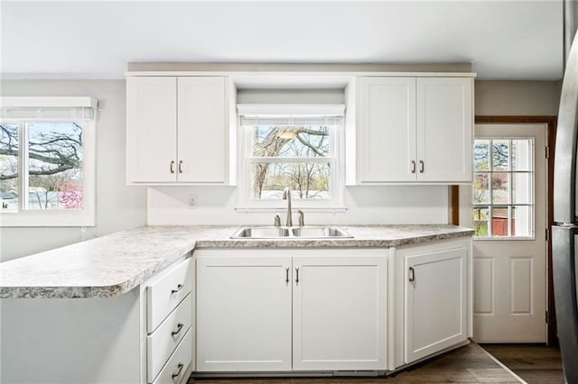 kitchen with white cabinets, a wealth of natural light, and sink