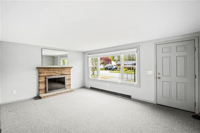 unfurnished living room featuring carpet floors, a brick fireplace, and a baseboard heating unit